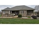 An outdoor wooden deck features comfortable seating, an umbrella, and a relaxing space adjacent to the house at 6089 W Hellis Dr, Muncie, IN 47304