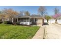 Charming stone home featuring a cozy screened-in porch and well-manicured lawn at 6120 Norwaldo Ave, Indianapolis, IN 46220