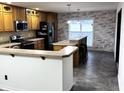 Charming kitchen featuring wooden cabinets, stainless steel appliances, and a breakfast bar with pendant lighting at 6431 W 800 S, Pendleton, IN 46064