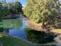 Scenic view of a tranquil pond with a fountain, enhanced by lush greenery and mature trees at 7220 Village Parkway Dr # 8, Indianapolis, IN 46254