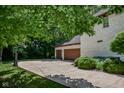 Spacious driveway leading to a two-car garage, complemented by a basketball hoop, lush greenery, and professional landscaping at 7957 Preservation Dr, Indianapolis, IN 46278