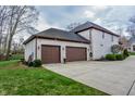 Attached two-car garage with dark doors complementing the white brick exterior of the house at 7957 Preservation Dr, Indianapolis, IN 46278