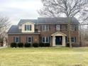 Traditional two-story brick home featuring dark shutters, manicured shrubs, and a well-maintained lawn at 8201 E 250 S, Zionsville, IN 46077