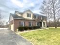 Traditional brick home featuring an attached garage, dark shutters, and a well-maintained lawn at 8201 E 250 S, Zionsville, IN 46077