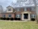 Traditional brick home with dark shutters, a covered entryway, and a well-kept lawn at 8201 E 250 S, Zionsville, IN 46077