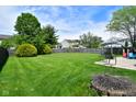 Expansive backyard with lush green grass, mature trees, a privacy fence, and a stamped concrete patio for outdoor entertaining at 10622 Young Lake Dr, Indianapolis, IN 46239