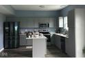 Modern kitchen with stainless steel appliances, gray cabinets, and center island at 1071 Hazelwood Dr, Greenwood, IN 46143