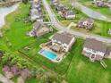 Aerial view of a suburban neighborhood with well-maintained lawns, community ponds, and mature trees at 13974 Nina Dr, Carmel, IN 46074