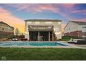 Backyard pool with screened in porch, patio with outdoor seating, and well maintained lawn at 13974 Nina Dr, Carmel, IN 46074