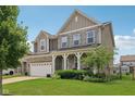 Beautiful two-story home featuring stone accents, a covered front porch, and lush landscaping at 16491 Wheatley Ct, Fishers, IN 46040