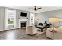 A naturally lit open living space with a fireplace, hardwood floors, and comfortable seating at 16491 Wheatley Ct, Fishers, IN 46040