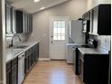Modern kitchen featuring sleek, dark cabinetry, stainless steel appliances, and a convenient washer/dryer combo at 1922 N Cherry St, Columbus, IN 47201