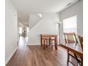 Hallway with wooden floors, a table and stools, and views of the kitchen and staircase at 2416 Meadow Bend Dr, Columbus, IN 47201