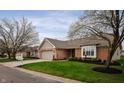 Inviting single story brick home with well-maintained landscaping, mature trees, and attached garage at 2813 W Long Meadow Ln, Muncie, IN 47304