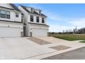 New construction home with white siding, black trim, driveway, and two car garage at 3240 Arabian Ln, Zionsville, IN 46077