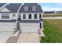 New construction home featuring white siding, black trim and a two-car garage at 3240 Arabian Ln, Zionsville, IN 46077
