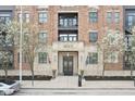 Beautiful brick building with stone accents, flags, flowering trees, and black framed windows at 355 E Ohio St # 309, Indianapolis, IN 46204