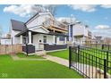 A charming two-story home with a black brick foundation, a deck, and a fenced front yard at 415 S Oxford St, Indianapolis, IN 46201