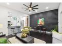 Modern living room boasts an open floor plan, black accent wall, bar seating, and hardwood floors at 415 S Oxford St, Indianapolis, IN 46201