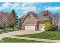 Beautiful brick home with three-car garage and landscaped front yard at 4421 Brittany Dr, Zionsville, IN 46077