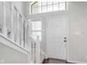 Bright foyer featuring a white staircase and a welcoming front door at 4421 Brittany Dr, Zionsville, IN 46077