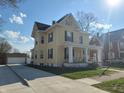 Lovely two-story yellow home with a long driveway and detached garage at 509 E Columbus St, Martinsville, IN 46151