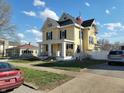 Charming yellow two-story home featuring a front porch and mature landscaping at 509 E Columbus St, Martinsville, IN 46151