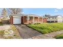 A cozy single-story house with a front-facing garage and a well-kept front lawn at 5838 W Henry St, Indianapolis, IN 46241