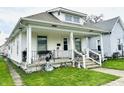 Traditional home featuring a covered porch with decorative railings and a well-manicured lawn at 640 W South St, Shelbyville, IN 46176