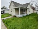Inviting covered front porch with concrete steps and space for outdoor seating at 648 W South St, Shelbyville, IN 46176