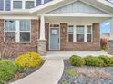 Inviting front entry with a blue door, brick facade, decorative stone accents, and meticulously landscaped garden at 682 Keswick Dr, Brownsburg, IN 46112