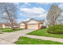 Well-maintained single-story home with attached two-car garage and landscaped lawn at 7150 Brant Pointe Cir, Indianapolis, IN 46217