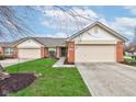 Home exterior with a two-car garage, brick accents, and a beautifully maintained lawn at 7150 Brant Pointe Cir, Indianapolis, IN 46217