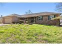 Brick home boasts a well-maintained lawn with green shutters and mature landscaping at 745 W Banta Rd, Indianapolis, IN 46217