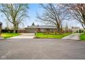 Brick home with manicured lawn, mature trees, and an inviting curb appeal at 7714 Kenneth Ct, Brownsburg, IN 46112