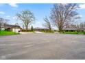 Residential street view featuring well-maintained homes and lush mature trees at 7714 Kenneth Ct, Brownsburg, IN 46112