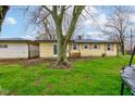 View of the home exterior with a spacious backyard featuring healthy green grass and mature trees at 7764 S State Road 109, Markleville, IN 46056