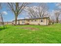Wide backyard with mature trees, healthy lawn, and an inviting view of the home's exterior at 7764 S State Road 109, Markleville, IN 46056
