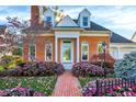 Inviting brick home with arched windows, a welcoming front porch, and lush flowers at 8040 Lynch Ln, Indianapolis, IN 46250