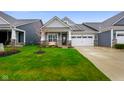 Beautifully landscaped front yard with vibrant green grass and inviting covered porch at 8160 Nik St, Brownsburg, IN 46112