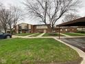 Attractive townhouse community showcasing lush lawns, mature trees, and convenient covered parking at 914 Greenwood E Trl, Greenwood, IN 46142