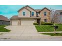 Spacious two-story home with a three-car garage and a well-manicured front lawn at 10016 Jenna Ln, Indianapolis, IN 46239