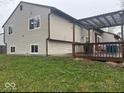 Backyard view of home with a deck, lawn, and gray siding at 10047 Lone Wolf Dr, Indianapolis, IN 46235