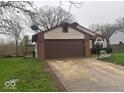 Exterior view of house showing the attached garage, brick facade, and driveway at 10047 Lone Wolf Dr, Indianapolis, IN 46235