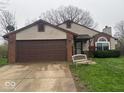 Front exterior view of the house with a two-car garage and well-maintained lawn at 10047 Lone Wolf Dr, Indianapolis, IN 46235
