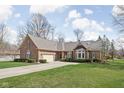 Attractive brick home featuring an attached garage, a curved driveway, and well-maintained landscaping at 10109 Fergus Ave, Carmel, IN 46032