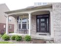 Inviting front porch with classic columns, a comfortable bench, and a stylish front door at 10365 Aurora Ct, Fishers, IN 46038