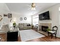 Comfortable living room with a stone fireplace, ceiling fan, and an abundance of natural light at 11339 Fonthill Dr, Indianapolis, IN 46236