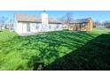 View of the house with a large well-manicured backyard, patio, and storage shed at 1222 Lynnwood Dr, Anderson, IN 46012