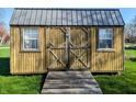 Well-maintained backyard storage shed with double doors and a ramp at 1222 Lynnwood Dr, Anderson, IN 46012